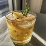 ['Close-up of a refreshing Pear Mocktail with ice and garnished with rosemary.', 'Side view of a Pear Mocktail in a glass, highlighting its frothy top and pear slice.', 'A beautifully crafted Pear Mocktail featuring pear slices and a sprig of rosemary.', 'Detailed shot of a Pear Mocktail with mineral water, ice, and a hint of cinnamon.']