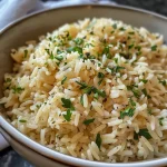 ['Close-up view of perfectly cooked rice pilaf garnished with chopped parsley.', 'Side view of a vibrant rice pilaf dish featuring vermicelli and fresh herbs.', 'Juicy rice pilaf displayed in a bowl with grains and golden vermicelli strands.', 'Detailed image of rice pilaf showcasing its fluffy texture and seasonings.']