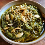 ['Close-up view of a vibrant green pumpkin seed pesto in a bowl.', 'A colorful presentation of pumpkin seed pesto with fresh herbs and garlic in focus.', 'Side view of a creamy pumpkin seed pesto surrounded by its fresh ingredients.', 'Rich green pumpkin seed pesto displayed with basil, parsley, and garlic cloves nearby.']