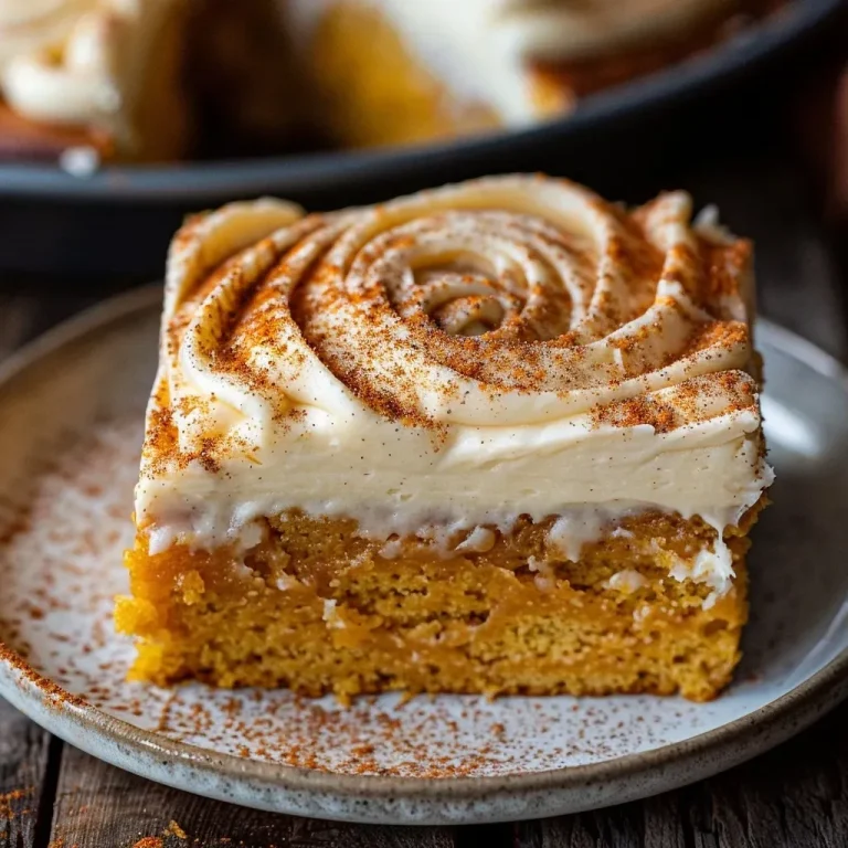 ['Side view of a moist pumpkin sheet cake topped with creamy frosting.', 'Close-up of a pumpkin sheet cake with a layer of cream cheese frosting.', 'Juicy pumpkin sheet cake displayed with rich cream cheese icing.', 'Detailed view of pumpkin sheet cake featuring luscious cream cheese topping.']