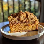 ['Close-up view of a moist Pumpkin Spice Crumb Cake with a crumbly topping.', 'Side view of a luscious Pumpkin Spice Crumb Cake showcasing its rich layers.', 'Detailed image of Pumpkin Spice Crumb Cake with a golden-brown crust and crumbles.', 'Close view of a slice of Pumpkin Spice Crumb Cake adorned with spices and texture.']