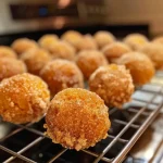 ['Close-up of fluffy pumpkin spice donut holes dusted with cinnamon sugar.', 'Side view of golden-brown pumpkin spice donut holes arranged on a plate.', 'Juicy pumpkin spice donut holes with a soft texture and warm color.', 'Mouthwatering pumpkin spice donut holes ready to be enjoyed, close-up shot.']