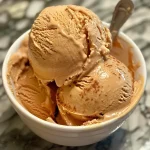 ['Close-up of creamy Pumpkin Spice Ice Cream in a bowl.', 'Side view of a luscious scoop of Pumpkin Spice Ice Cream.', 'Detailed shot of Pumpkin Spice Ice Cream with autumn spices.', 'Vivid image of a decadent scoop of Pumpkin Spice Ice Cream.']