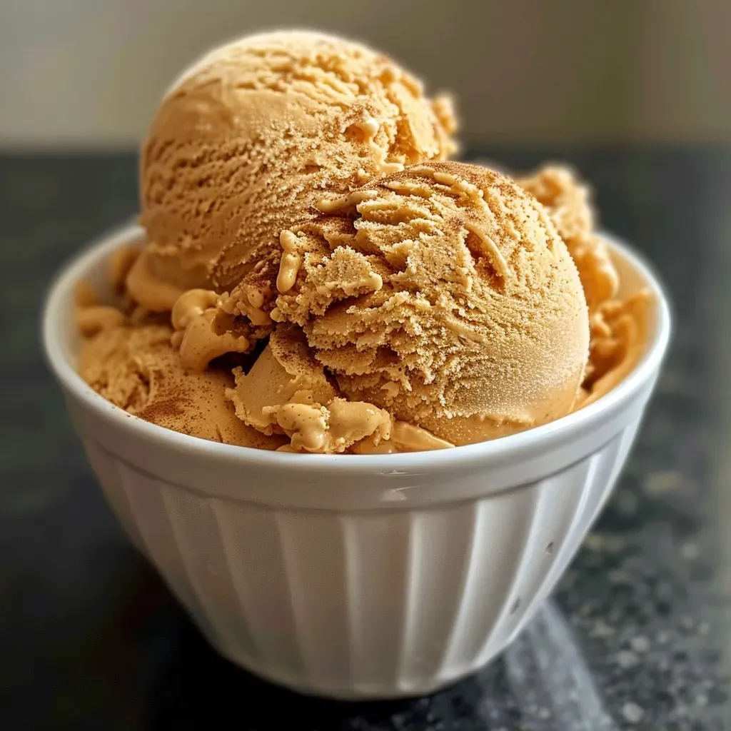 ['Close-up of creamy Pumpkin Spice Ice Cream in a bowl.', 'Side view of a luscious scoop of Pumpkin Spice Ice Cream.', 'Detailed shot of Pumpkin Spice Ice Cream with autumn spices.', 'Vivid image of a decadent scoop of Pumpkin Spice Ice Cream.']