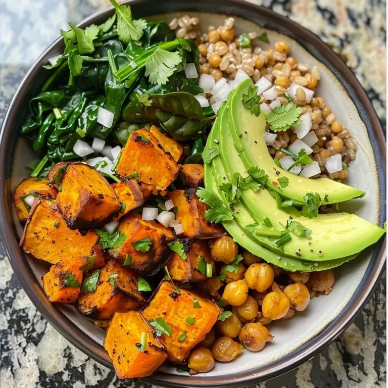 ['A close-up view of a colorful bowl filled with roasted sweet potatoes, chickpeas, and fresh spinach.', 'A side view of a vibrant Roasted Sweet Potato and Chickpea Bowl showcasing diced sweet potatoes and chickpeas.', 'A deliciously arranged bowl featuring roasted sweet potatoes, chickpeas, and avocado slices over brown rice.', 'A mouthwatering bowl of roasted sweet potatoes, chickpeas, spinach, and toppings like avocado and herbs.']