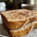 ['Close-up of slow cooker cinnamon apple bread with a golden brown crust and chunks of apples.', 'Side view of a loaf of cinnamon apple bread, highlighting its moist texture and cinnamon dusting.', 'Juicy, homemade cinnamon apple bread in a slow cooker, with apple pieces visible on the surface.', 'Freshly baked cinnamon apple bread showcasing a soft interior and warm, aromatic crust.']