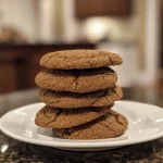 ['A close-up view of spiced molasses cookies with a soft texture and a shiny glaze.', 'A side view of freshly baked spiced molasses cookies showcasing their chewy surface and warm color.', 'A detailed shot of delicious spiced molasses cookies, highlighting the spices and granulated sugar topping.', 'An enticing look at a batch of spiced molasses cookies, with a focus on their rich, dark coloring.']