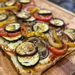 ['Close-up view of a Roasted Vegetable Flatbread with vibrant colors and textures.', 'Side view of a freshly baked Roasted Vegetable Flatbread showcasing toppings.', 'Juicy Roasted Vegetable Flatbread featuring a medley of vegetables and cheese.', 'Delicious Roasted Vegetable Flatbread presented on a rustic surface.']