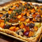 ['A close-up side view of a baked Roasted Vegetable Tart showcasing a golden crust filled with colorful vegetables.', 'A savory Roasted Vegetable Tart with flaky crust, featuring butternut squash, mushrooms, and red onions.', 'Delicious Roasted Vegetable Tart displayed at an angle, highlighting vibrant roasted vegetables and a rich creamy filling.', 'A freshly baked Roasted Vegetable Tart with a crispy exterior and a medley of roasted vegetables peeking through.']