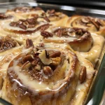 ['Close-up side view of golden-brown Maple Pecan Cinnamon Rolls drizzled with icing.', 'A tempting side view of freshly baked Maple Pecan Cinnamon Rolls with pecan pieces visible.', 'Juicy Maple Pecan Cinnamon Rolls topped with a creamy glaze and a sprinkle of chopped pecans.', 'A beautifully arranged Maple Pecan Cinnamon Rolls showcasing their gooey filling and golden crust.']