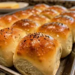 Close-up of golden, soft dinner rolls arranged on a plate.