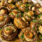 Close-up of juicy garlic butter mushrooms on a plate, showcasing a glistening texture.