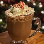 Close-up view of a rich Holiday Hot Chocolate topped with whipped cream and garnished with chocolate shavings.