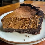 Close-up side view of a rich chocolate pumpkin torte with a glossy finish.