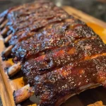 Juicy slow-smoked baby back ribs glistening with bourbon peach glaze.
