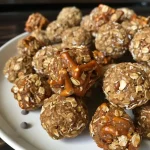 Close-up image of Sweet and Salty Peanut Butter Pretzel Bites arranged on a wooden surface.
